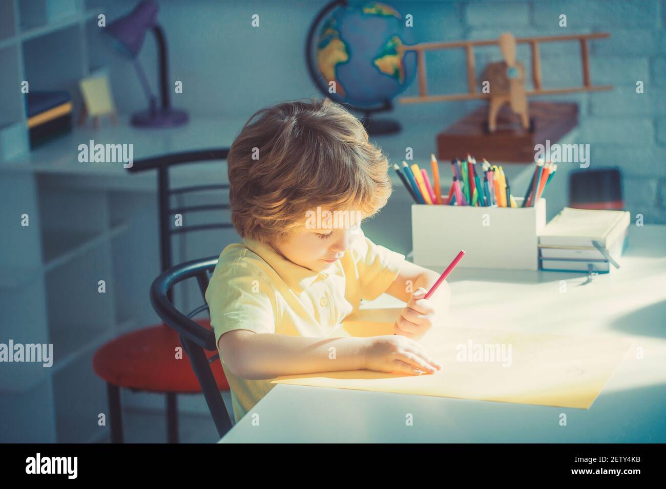 Kleiner Junge Zeichnung im Zimmer, Bildung und Kindertagesstätte. Stockfoto