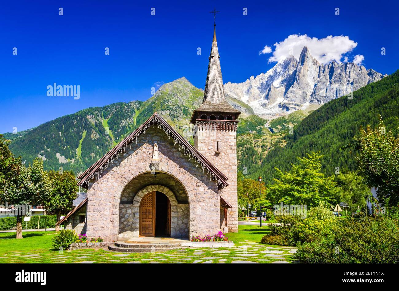 Chamonix, Frankreich. Alte Stein Les Praz Kirche in Chamonix Tal, Mont Blanc Berge Aiguille du Midi. Stockfoto