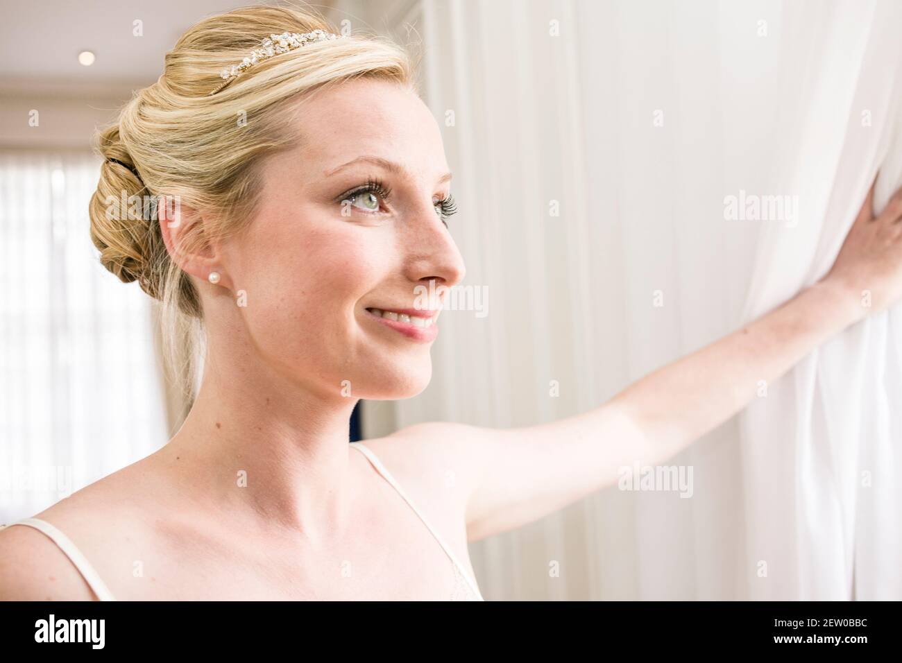 Braut lächelt an ihrem Hochzeitstag vor der Vorzeremonie Stockfoto