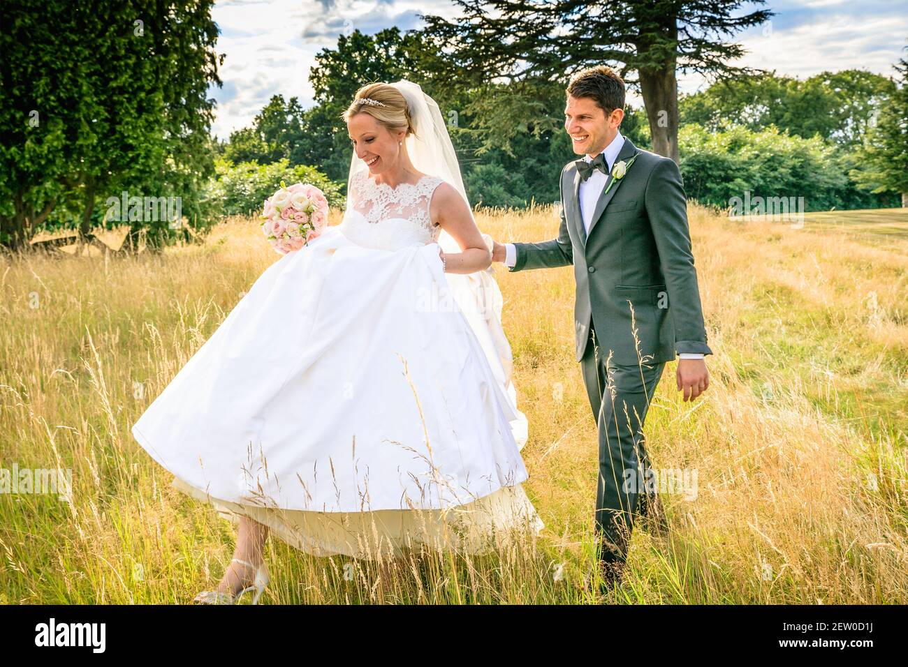 Braut und Bräutigam glücklich zusammen auf dem Feld von langem Gras Stockfoto