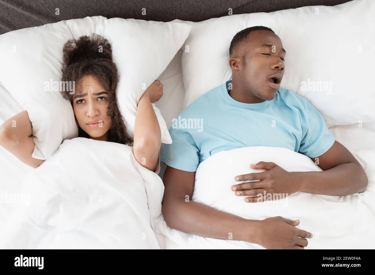 Schnarchen Mann schlafen mit Apnoe und schlaflosen Frau, wütend Frau nicht in der Lage zu schlafen Stockfoto