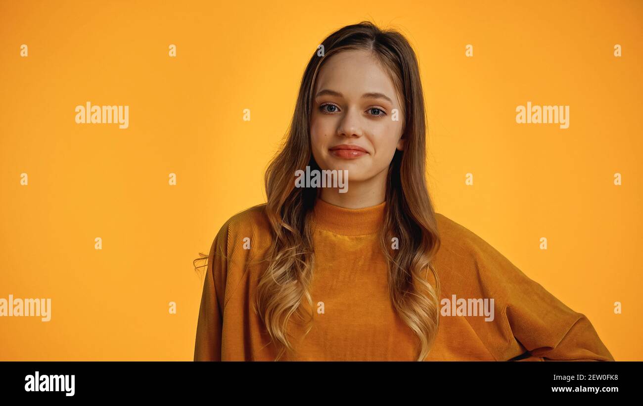Teenager Mädchen in weichen Pullover Blick auf Kamera isoliert auf Gelb Stockfoto
