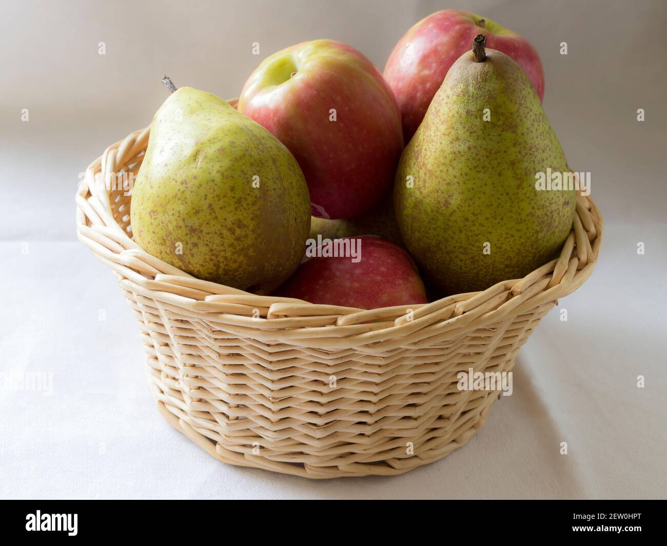 Ein Korbkorb gefüllt mit Äpfeln und Birnen Stockfoto