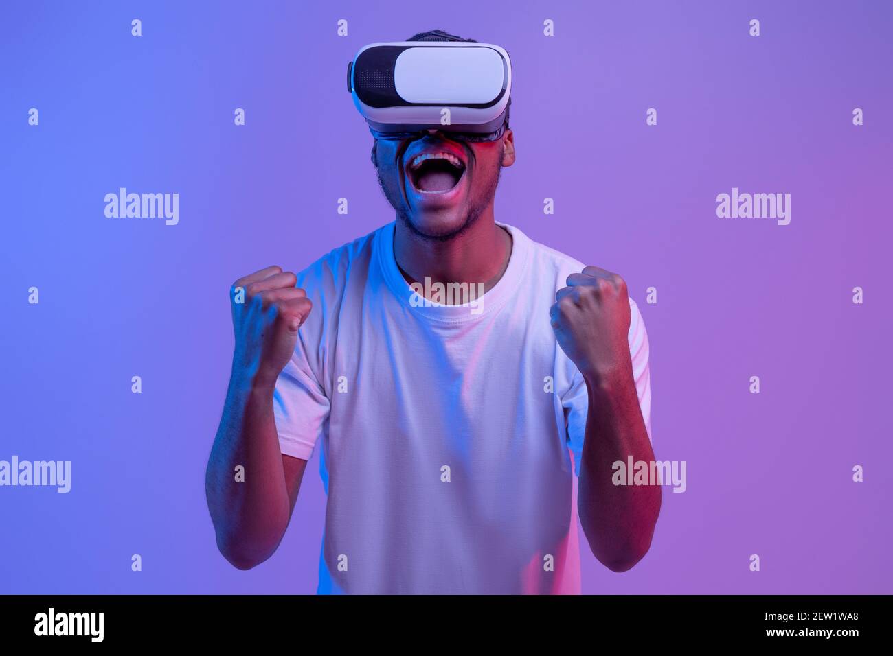 Überglücklich African American man in VR-Brille feiert Win in Videospiel Stockfoto