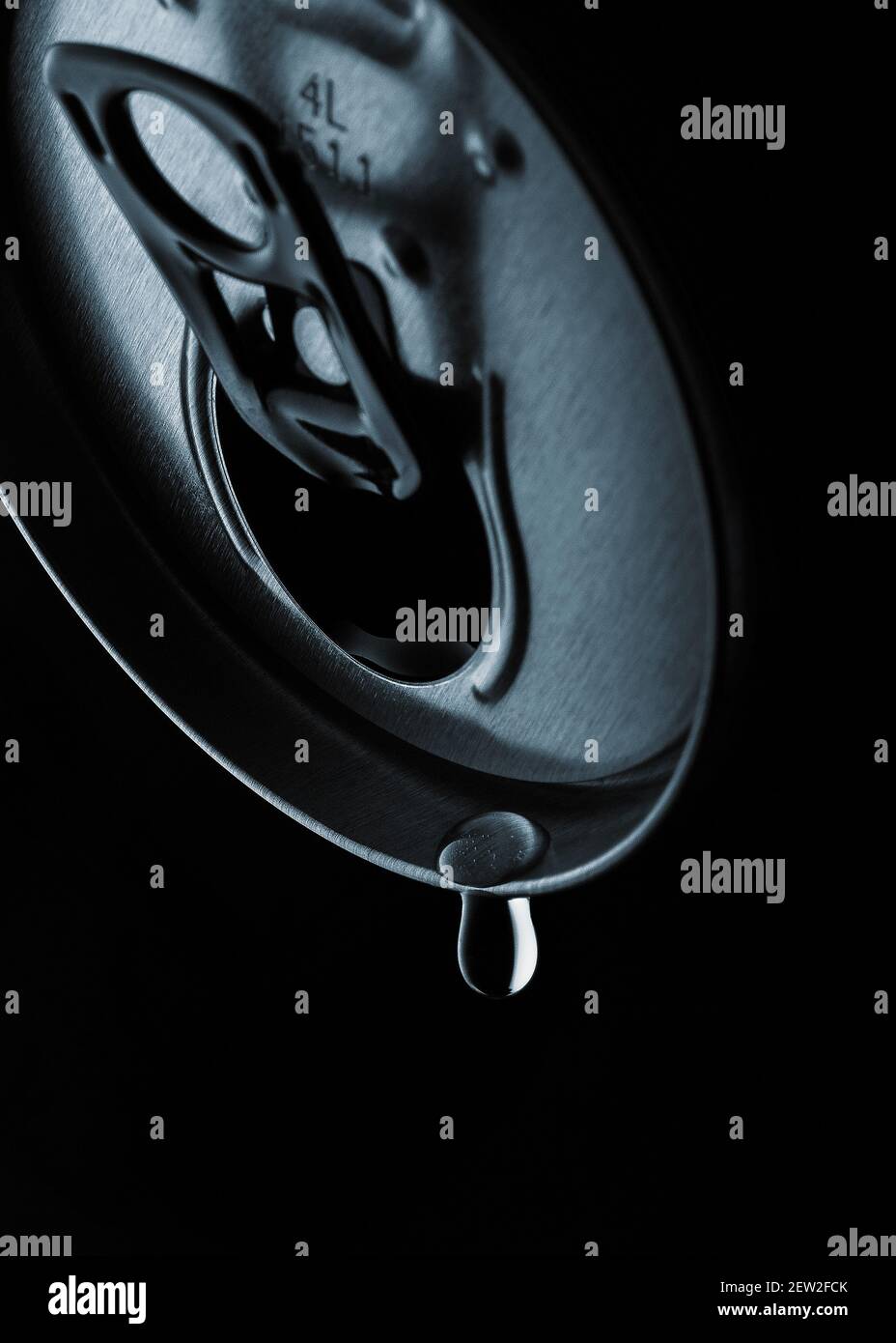Die obere Ansicht zeigt eine GetränkeDose mit dem letzten Tropfen des Getränks, der an der Getränkeöffnung hängt. Der Hintergrund ist schwarz gehalten und der Vordergrund ist m Stockfoto