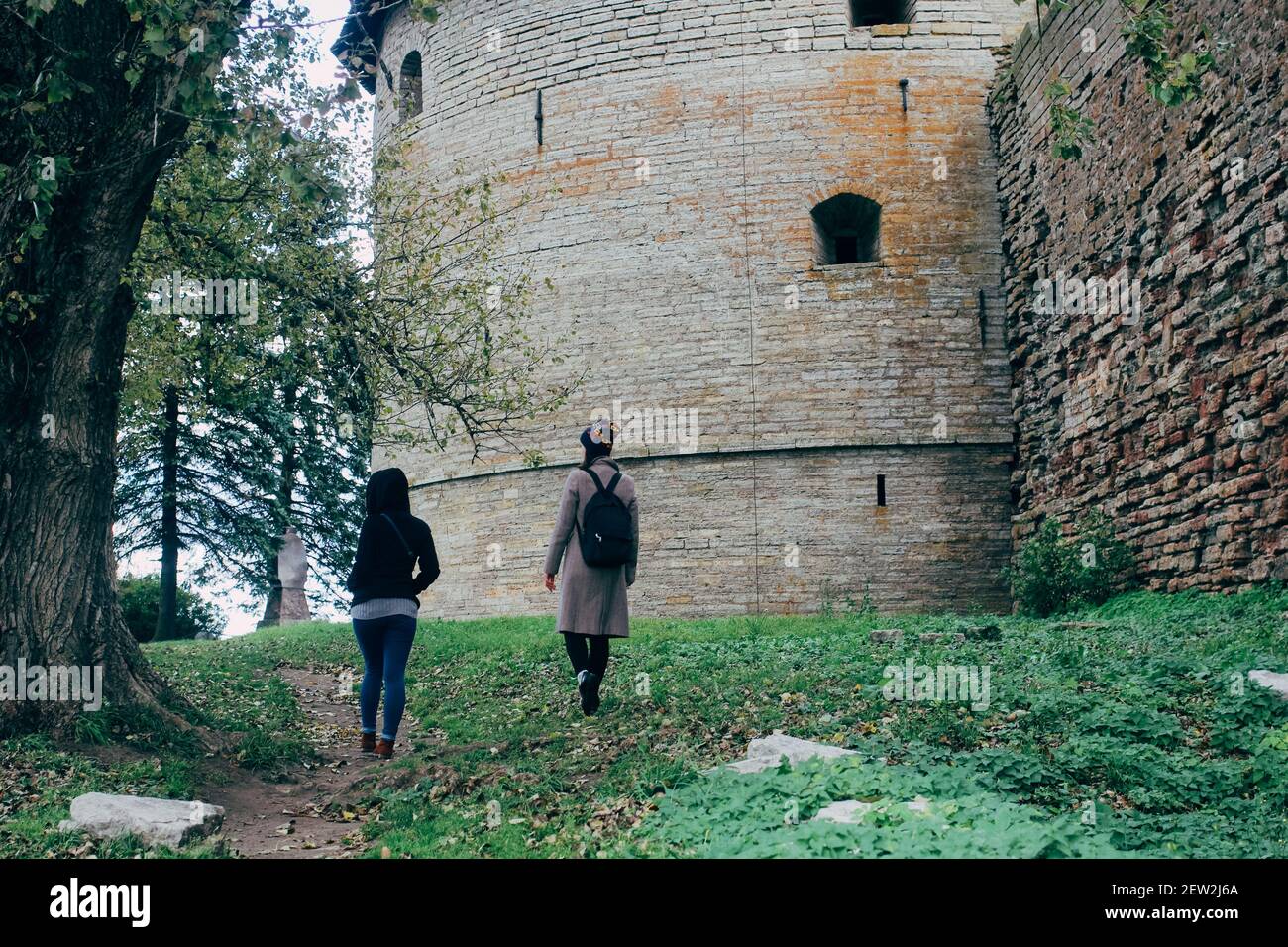 SANKT PETERSBURG, RUSSLAND - 01. Jun 2019: Zwei junge Touristen, die in der Nähe der mittelalterlichen Burg in Vyborg, Sankt Petersburg, spazieren Stockfoto