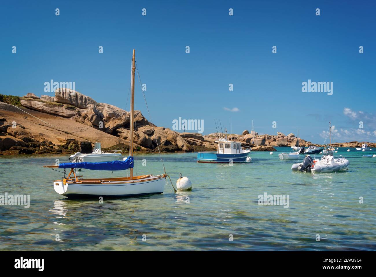 Boote und klares Wasser am Strand von Coz-Pors in Tregastel, Côtes d'Armor, Bretagne, Frankreich Stockfoto