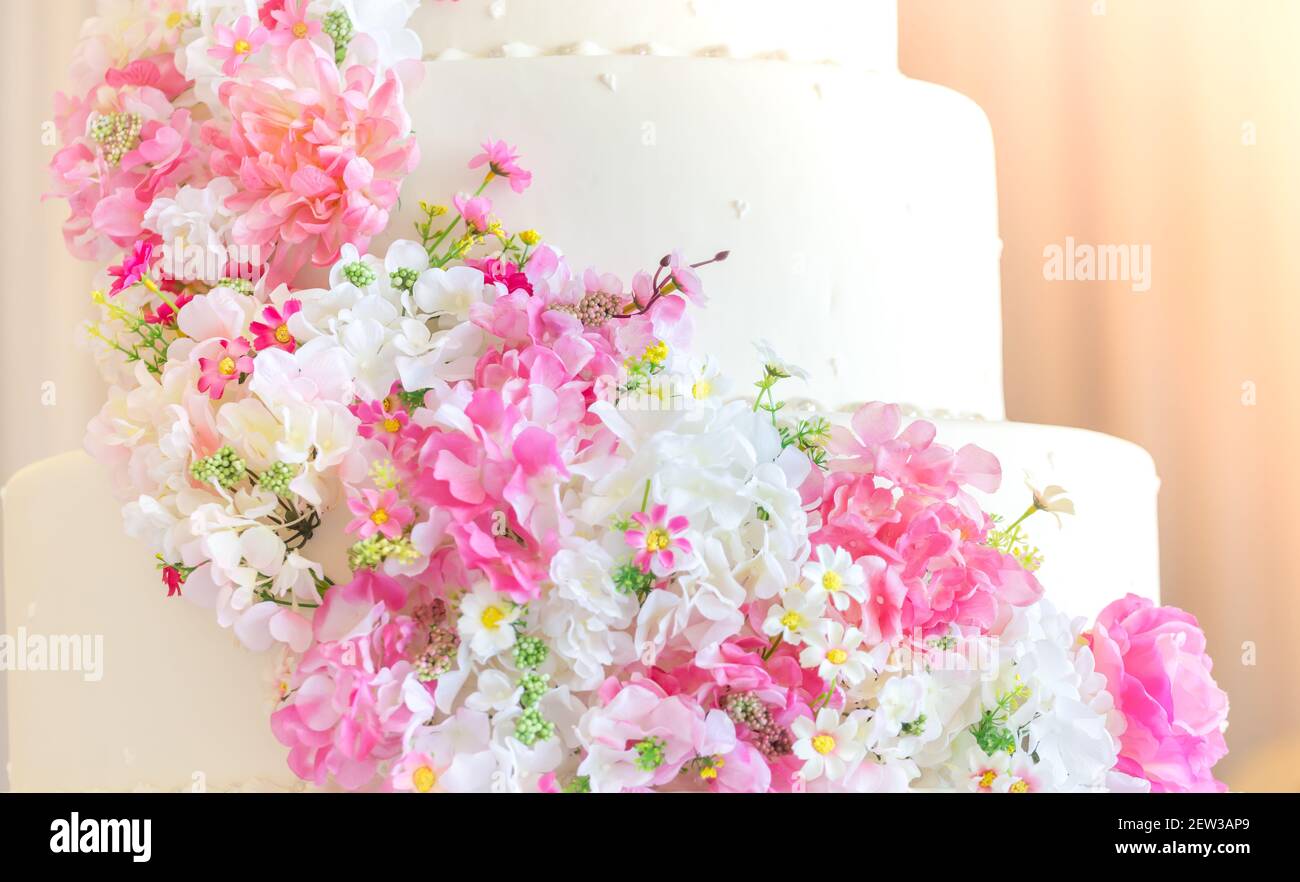 Weiße Hochzeitstorte mit Blumen an einem glücklichen Tag des Paares Stockfoto