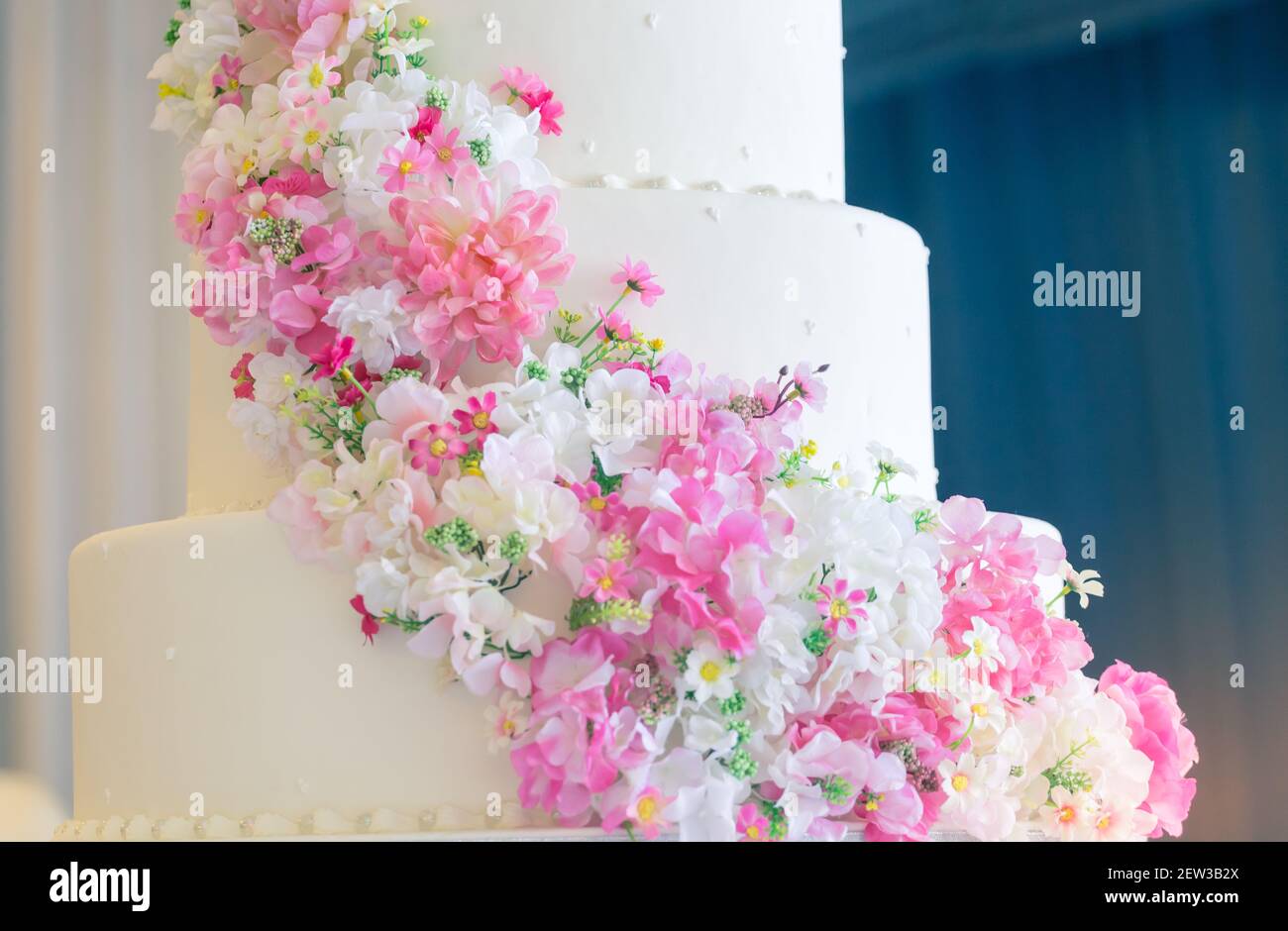 Weiße Hochzeitstorte mit Blumen an einem glücklichen Tag des Paares Stockfoto
