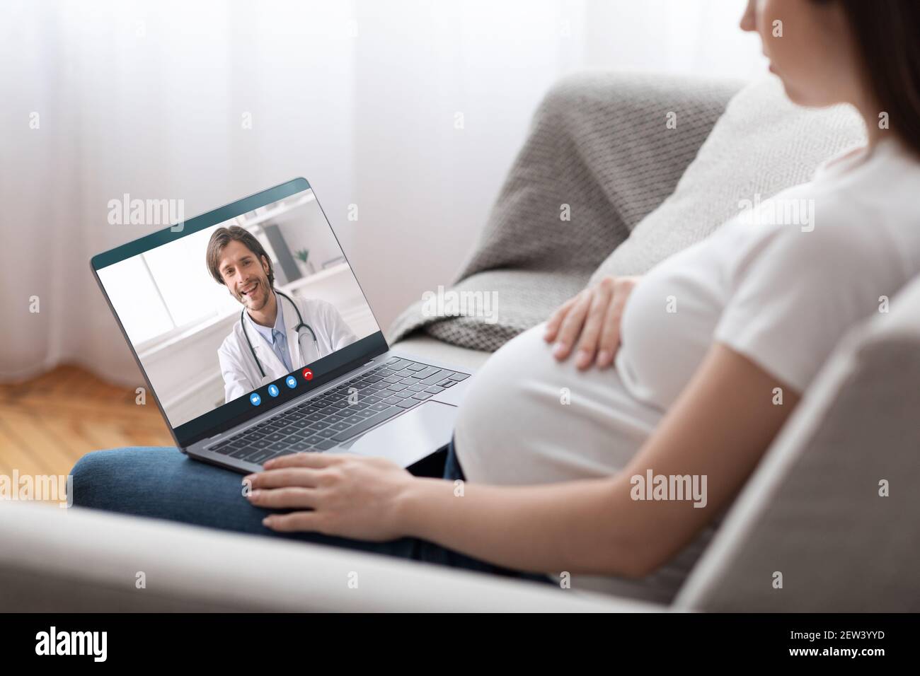 Online-Arzt. Junge Schwangere Dame Mit Laptop Machen Video Anruf Zu Gynäkologen Stockfoto