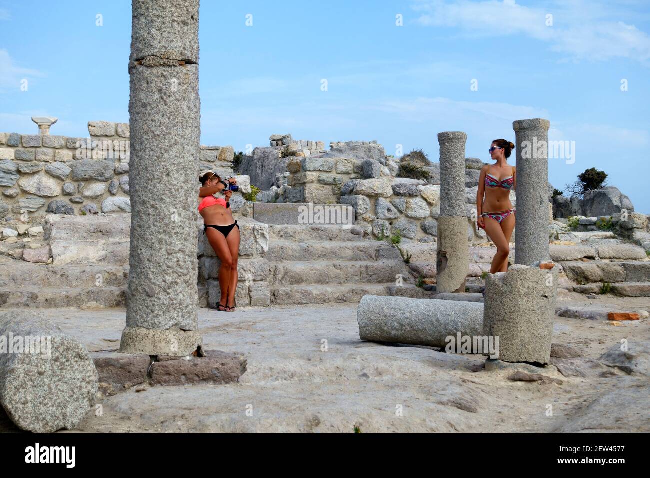 Mädchen in einem Bikini posiert und bekommen ihr Foto gemacht In den Ruinen der Basilika Agios Stefanos in Kefalos on Die griechische Insel Kos Stockfoto