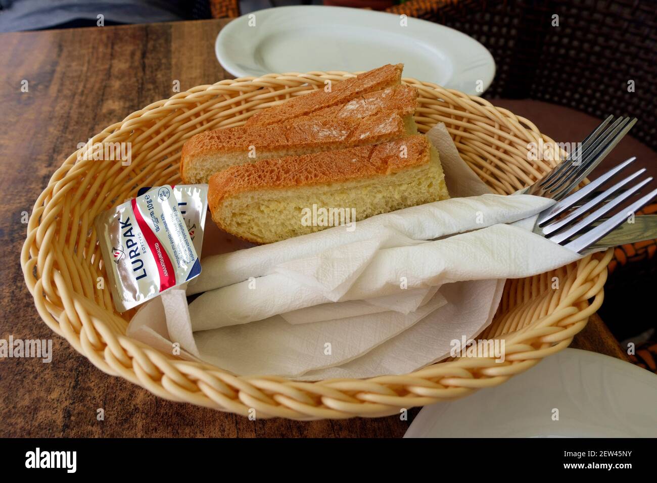 Korb mit Brot, Butter und Besteck, in der Regel in griechischen Restaurants serviert, bevor Ihre Mahlzeit ankommt Stockfoto