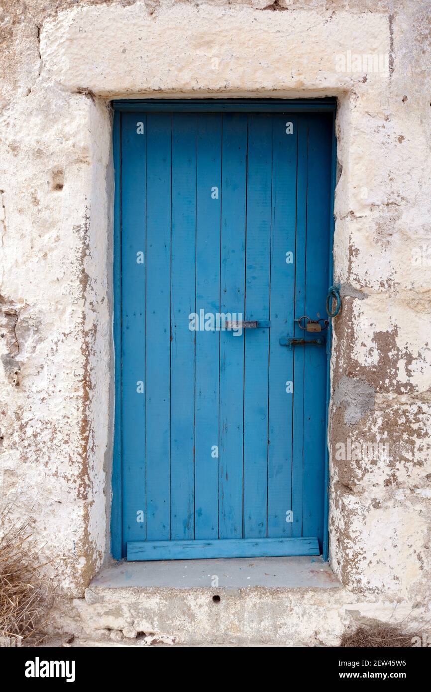 Blaue Tür mit Vorhängeschloss in einem alten Steingebäude in Griechenland Stockfoto