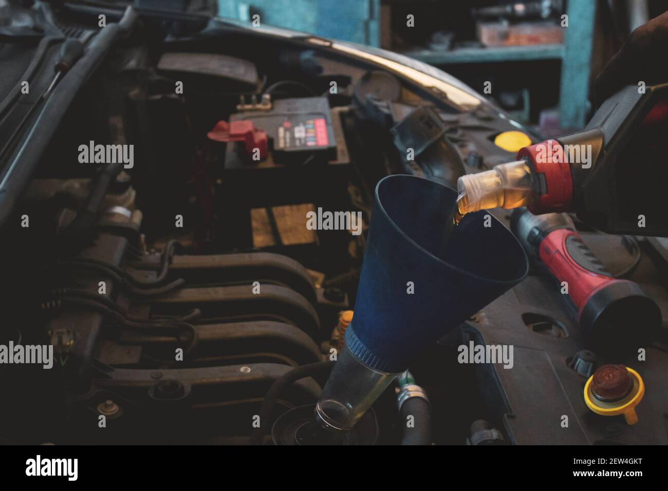 Hand eines professionellen Kfz-Mechanikers Nachfüllen Motoröl Stockfoto