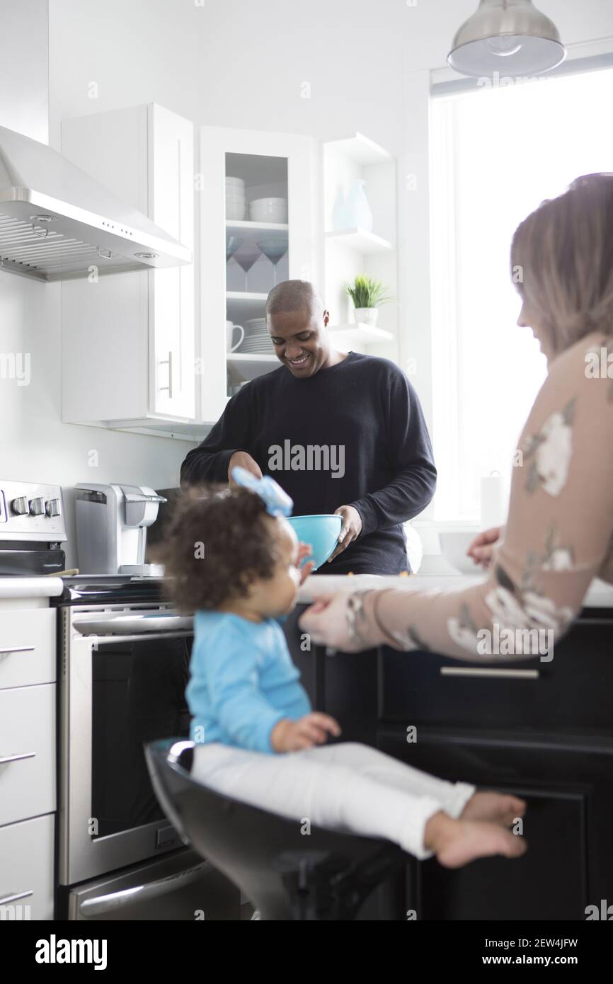 Eine junge interracial Familie Kochen und lachen zusammen in einer modernen Küche. Stockfoto