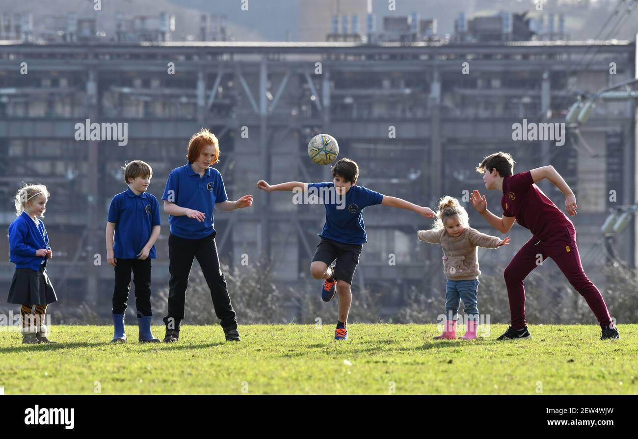 Kinder, die nach der Schule einen Fußball-Kick über Großbritannien, Großbritannien, 2021 Stockfoto