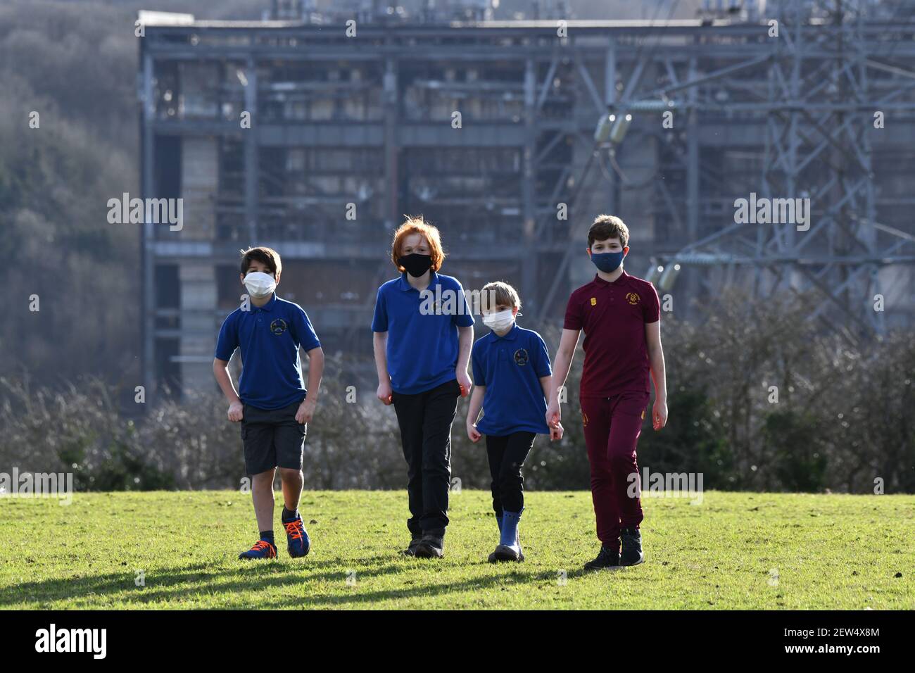 Schulkinder, die während einer Pandemie in der Nähe eines Industriestandorts mit Gesichtsmasken spazieren Großbritannien, Großbritannien, 2021 BILD VON DAVID BAGNALL Stockfoto