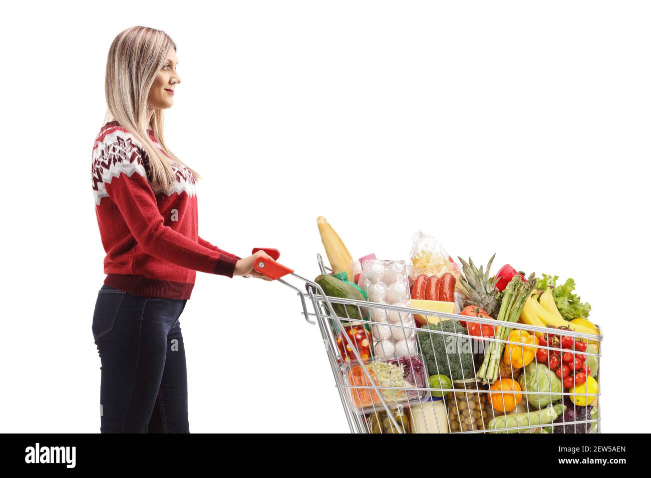 Junge Frau mit Essen in einem Einkaufswagen isoliert auf Weißer Hintergrund Stockfoto