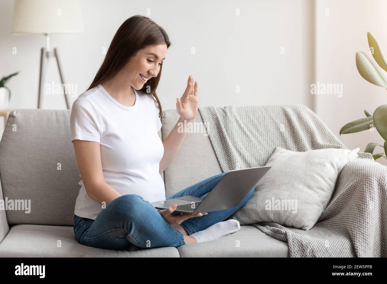 Fernkommunikation. Glücklich Schwangere Dame Mit Laptop Zu Hause Machen Videoanruf Stockfoto