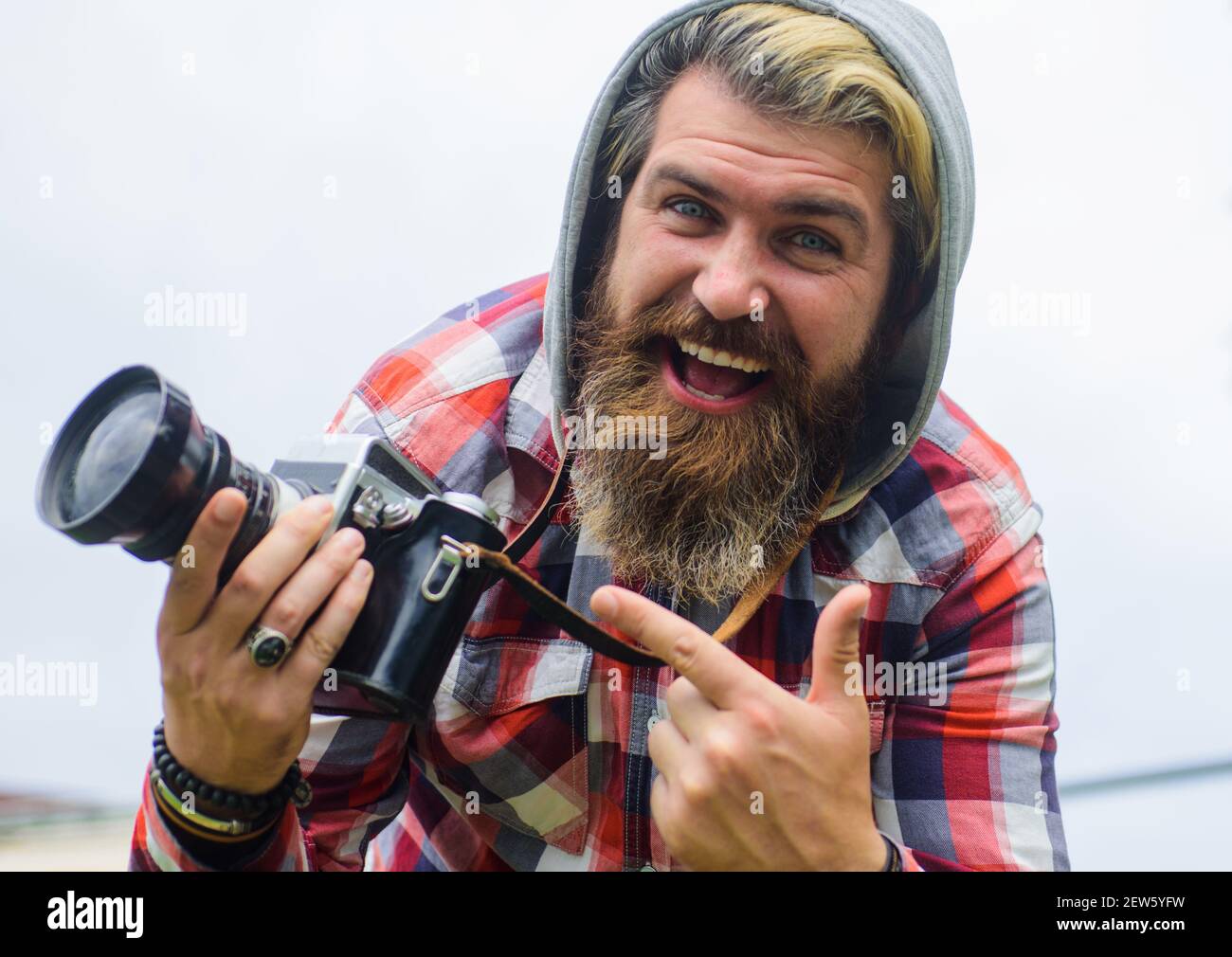Professioneller Fotograf, der mit einer Digitalkamera fotografiert. Bärtiger Mann Reisende machen Fotos auf der Straße. Reisen und Tourismus. Stockfoto