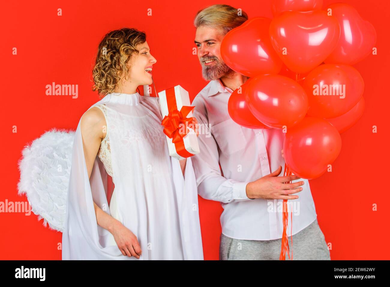 Schönes Paar am Valentinstag. Amor Engel mit Geschenken und Ballons. Paar am valentinstag. Stockfoto