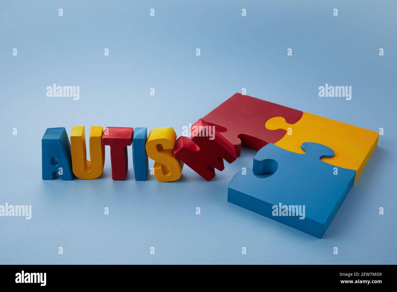 Autismus-Bewusstsein-Konzept mit Puzzle und Wort Autismus auf blauem Hintergrund. Stockfoto