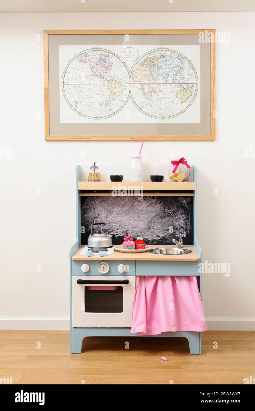 Kinderzimmermöbel. Holzküche für Kinder Spiel und Weltkarte auf einer Wand Copyspace Stockfoto