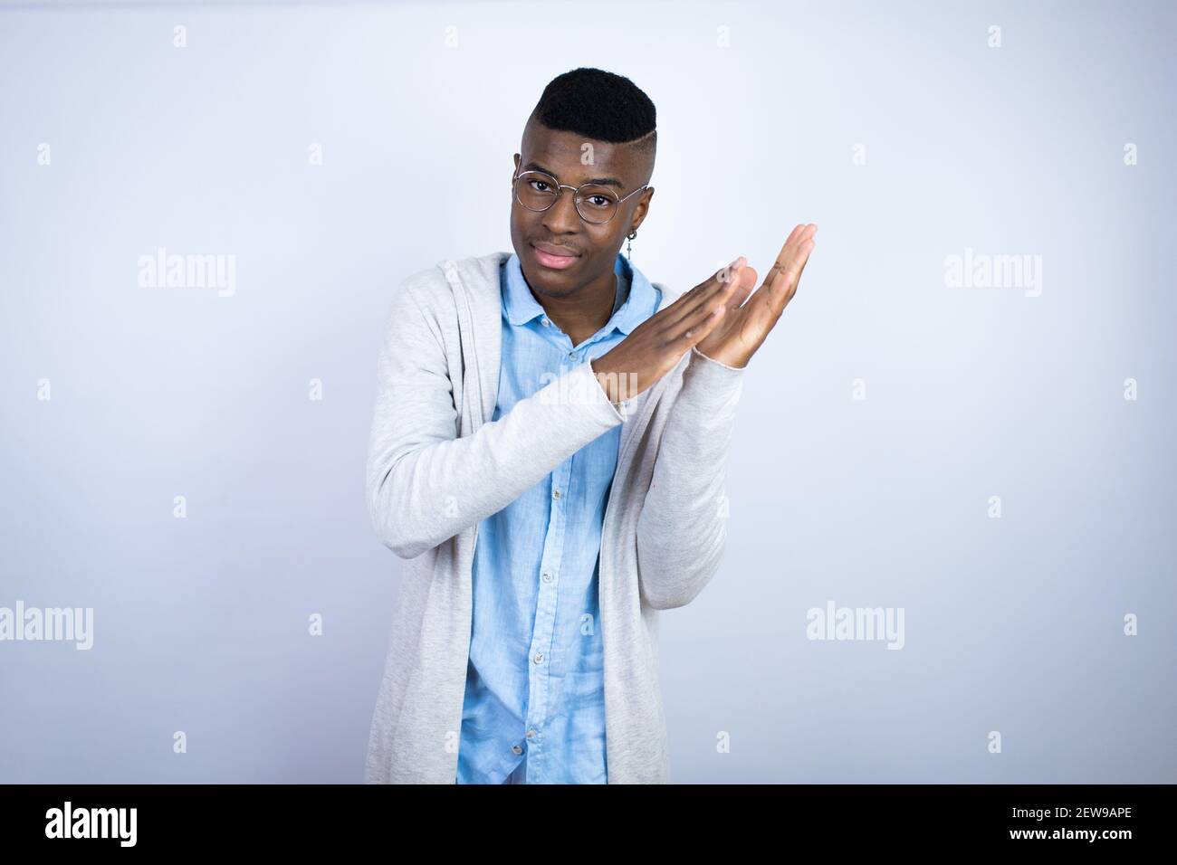 Junger schöner afroamerikanischer Mann in lässiger Kleidung klatscht und applaudiert glücklich und fröhlich, lächelnd stolze Hände zusammen Stockfoto