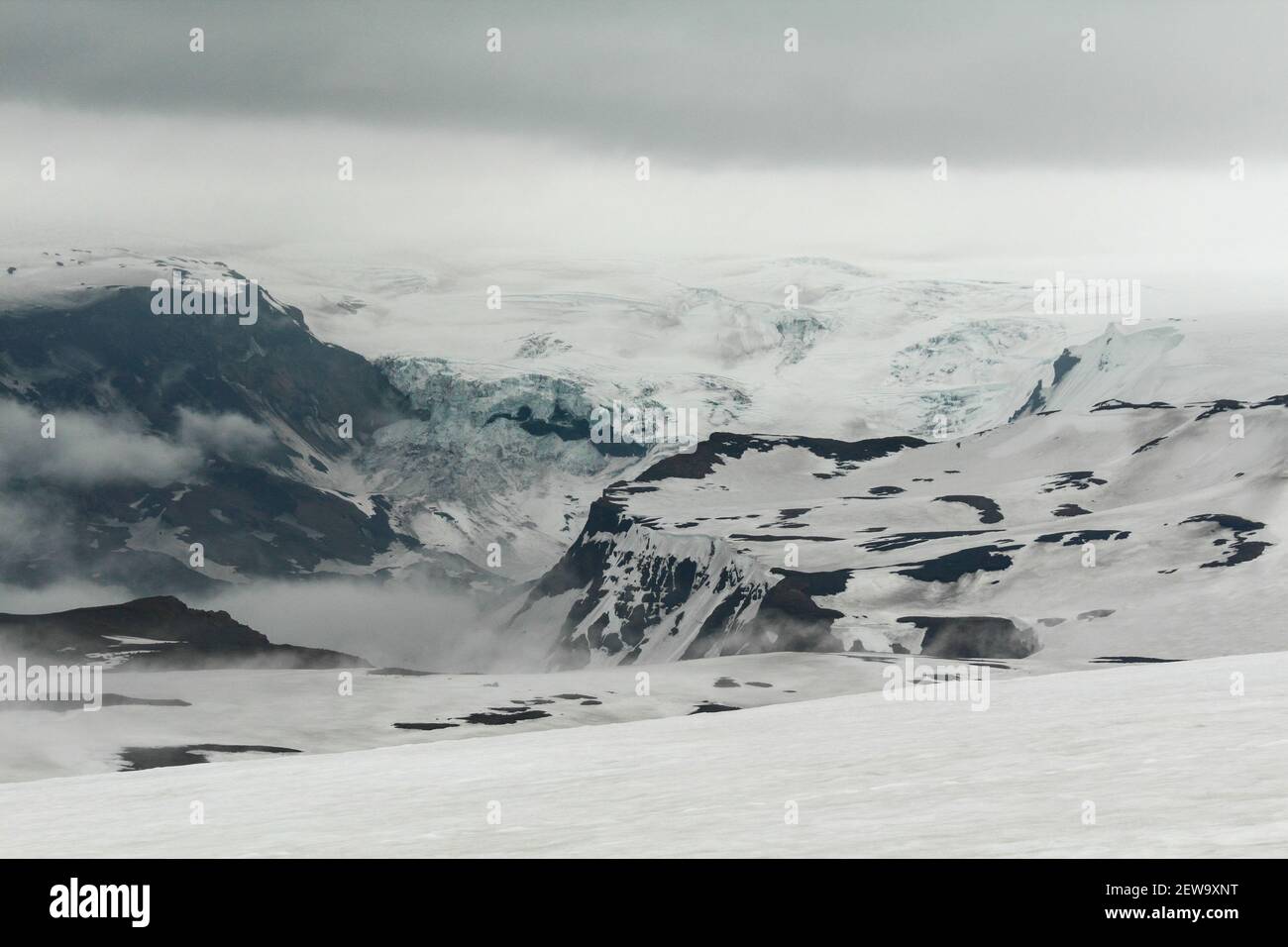 Schneebedeckte und neblig weiße Landschaft am Fimmvorduhals Wanderweg, ein Gletscher im Hintergrund, Island Stockfoto