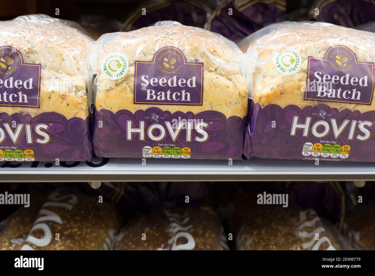 Drei Brote in Scheiben für Toast und Sandwiches in Regalen zum Verkauf im Supermarkt, Großbritannien Stockfoto