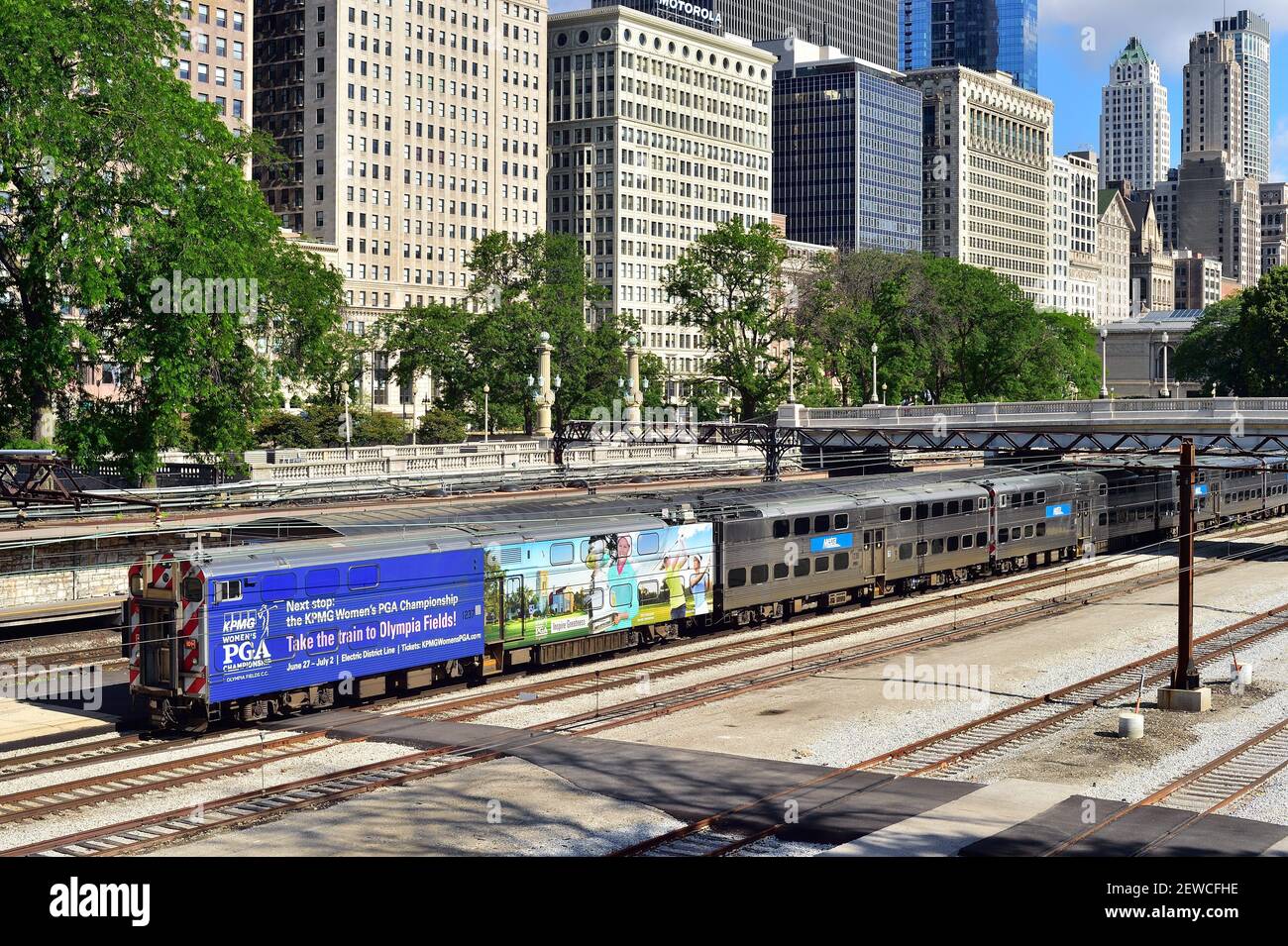 Chicago, Illinois, USA. Ein Metra Pendlerzug, komplett mit Werbung auf einem seiner Autos, Ankunft an der Van Buren Street Station. Stockfoto