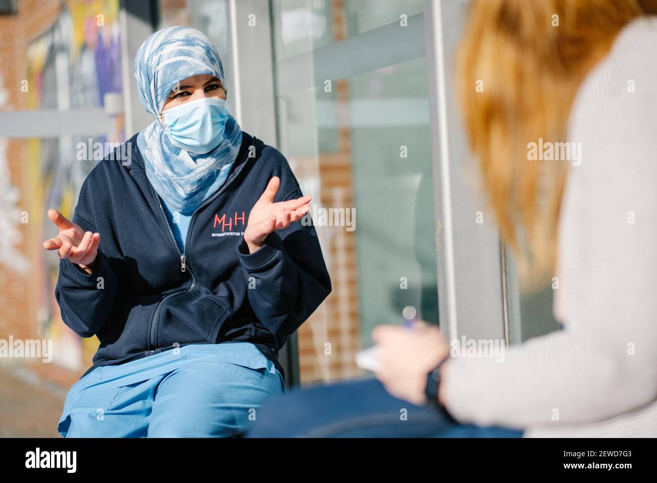 24. Februar 2021, Niedersachsen, Hannover: Farah Demir, Intensivkrankenschwester auf der Intensivstation Covid 19, spricht vor dem Campus der Medizinischen Hochschule Hannover (MHH) mit einer Journalistin. Demir lebt seit 34 Jahren in Deutschland, doch die Einwanderungsbehörden drohen ihr mit Abschiebung. Foto: Ole Spata/dpa Stockfoto