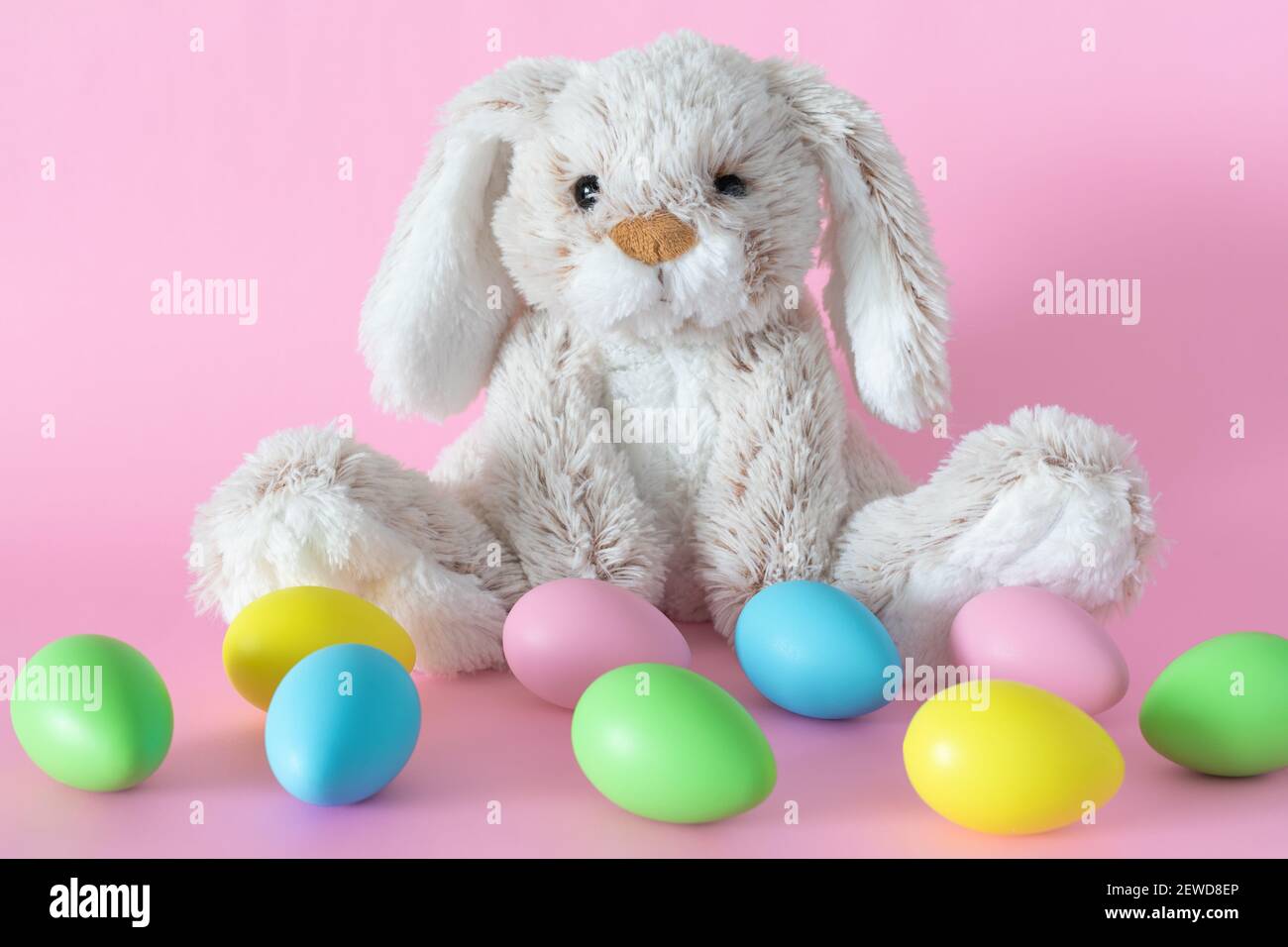 Ostern gefüllte Hase mit bunten Eiern auf rosa Hintergrund Stockfoto