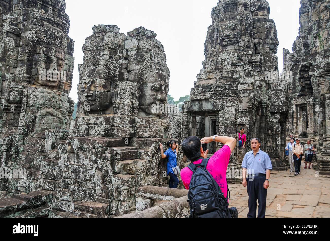 Angkor, Kambodscha - 27. März 2011. Touristen fotografieren die Bayon, die beeindruckendste Khmer-Ruine in Angkor Thom. Stockfoto