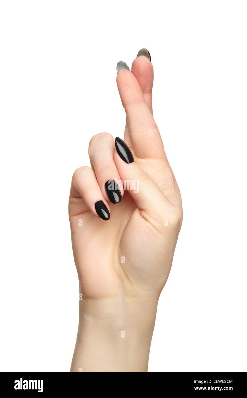 Weibliche Hand mit schwarzen Nägeln Maniküre mit gekreuzten Fingern. Isoliert auf weißem Hintergrund. Stockfoto