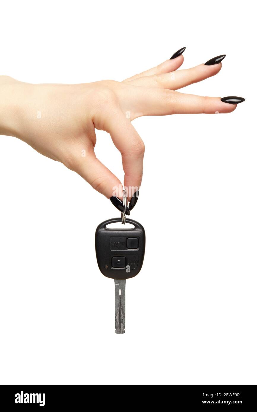 Eine weibliche Hand mit einer schwarzen Nägel Maniküre hält einen schwarzen Auto-Schlüssel mit ihren Fingern. Car-Sharing-Konzept. Isoliert auf weißem Hintergrund. Stockfoto