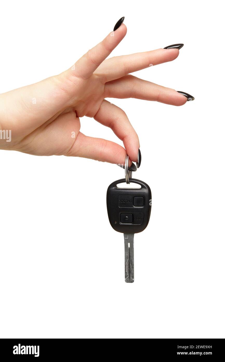 Eine weibliche Hand mit einer schwarzen Nägel Maniküre hält einen schwarzen Auto-Schlüssel mit ihren Fingern. Car-Sharing-Konzept. Isoliert auf weißem Hintergrund. Stockfoto