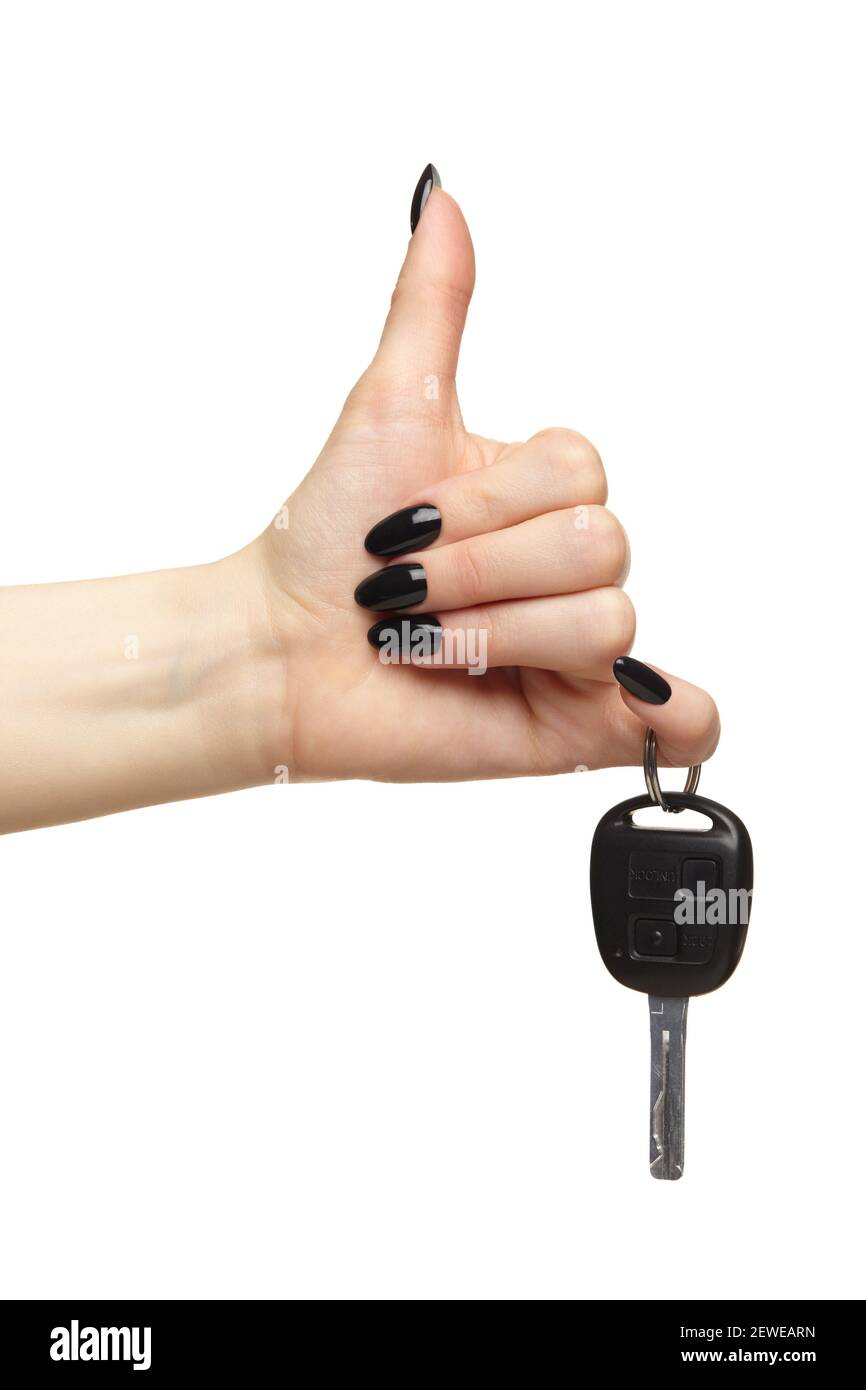 Eine weibliche Hand mit einer schwarzen Nägel Maniküre hält einen schwarzen Auto-Schlüssel mit ihren Fingern mit Daumen nach oben. Car-Sharing-Konzept. Isoliert auf weißem Hintergrund. Stockfoto