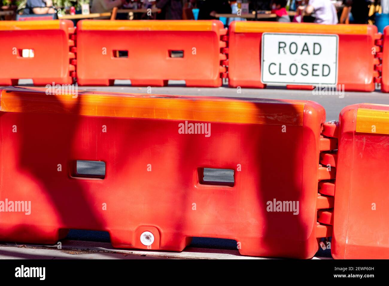 Verkehrssicherheit rotes Wasser gefüllt Kunststoff Barrikade blockiert den Verkehr An der Straße in der Innenstadt, die während zum Essbereich im Freien umgebaut wurde Das Coronavirus pand Stockfoto
