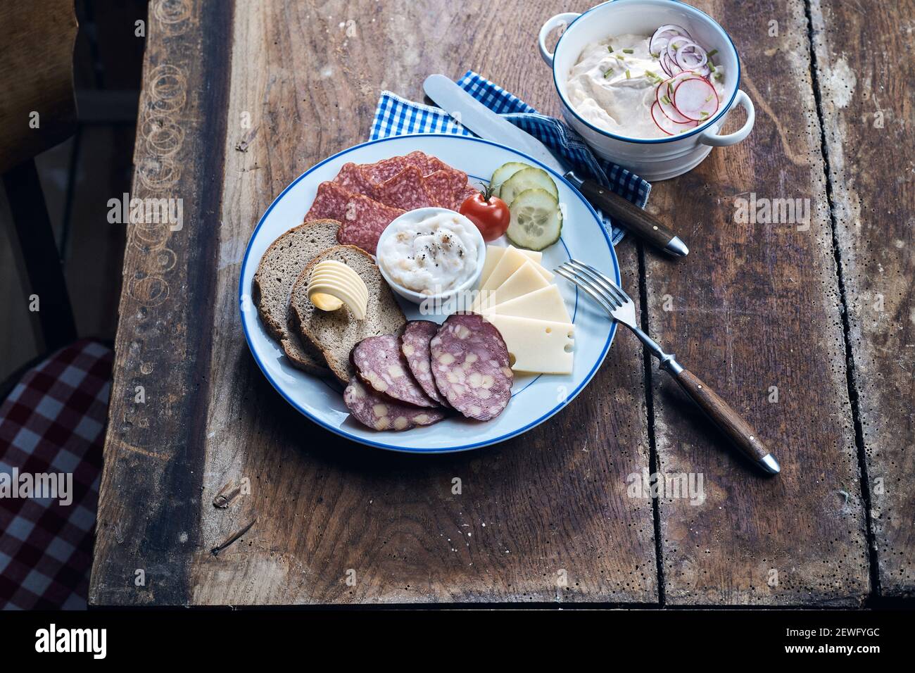 Hoher Winkel von köstlichen Wildwurst und Käse Scheiben mit Butter auf Roggenbrotstücken auf dem Teller Stockfoto