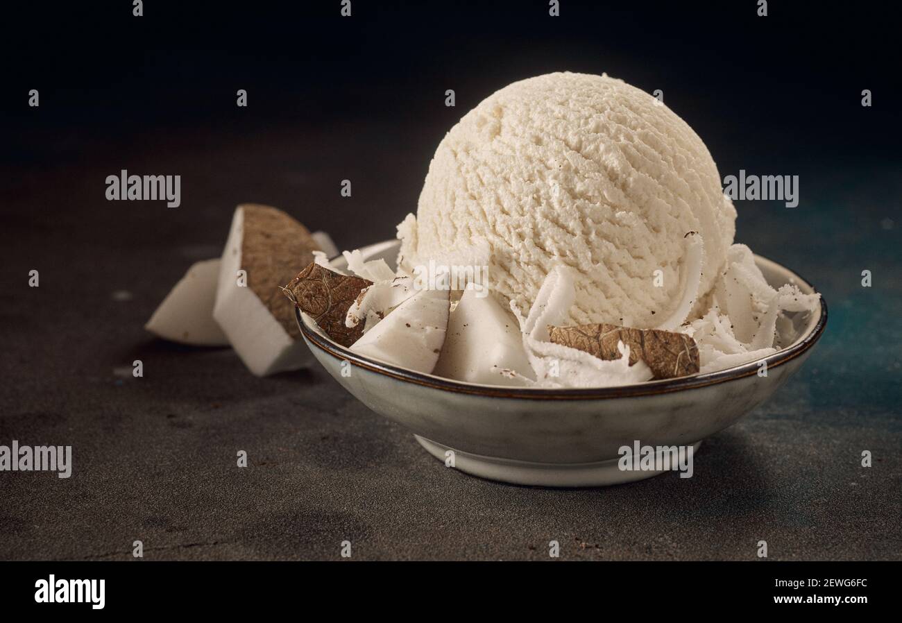 Appetitlich hausgemachter Eislöffel mit frischen Kokosnussstücken und dekoriert Serviert in einer Schüssel Stockfoto
