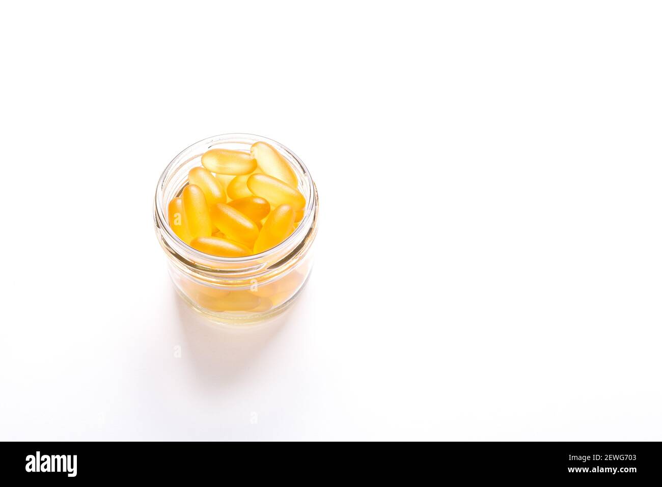Omega 3 Kapseln im Glas auf weißem Hintergrund Fischöl Gelbe Softgels Vitamin D, E, EINE Ergänzung Konzept der Gesundheitsversorgung Copy space Stockfoto