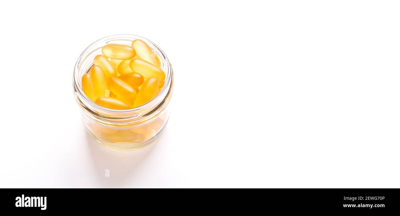 Omega 3 Kapseln im Glas auf weißem Hintergrund Fischöl Gelbe Softgels Vitamin D, E, EINE Ergänzung Banner Konzept der Gesundheitsversorgung Copy space Stockfoto