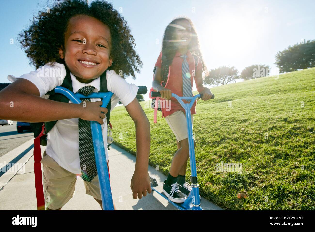 Ein 6-jähriger Junge und seine ältere Schwester Roller auf einem Weg Stockfoto