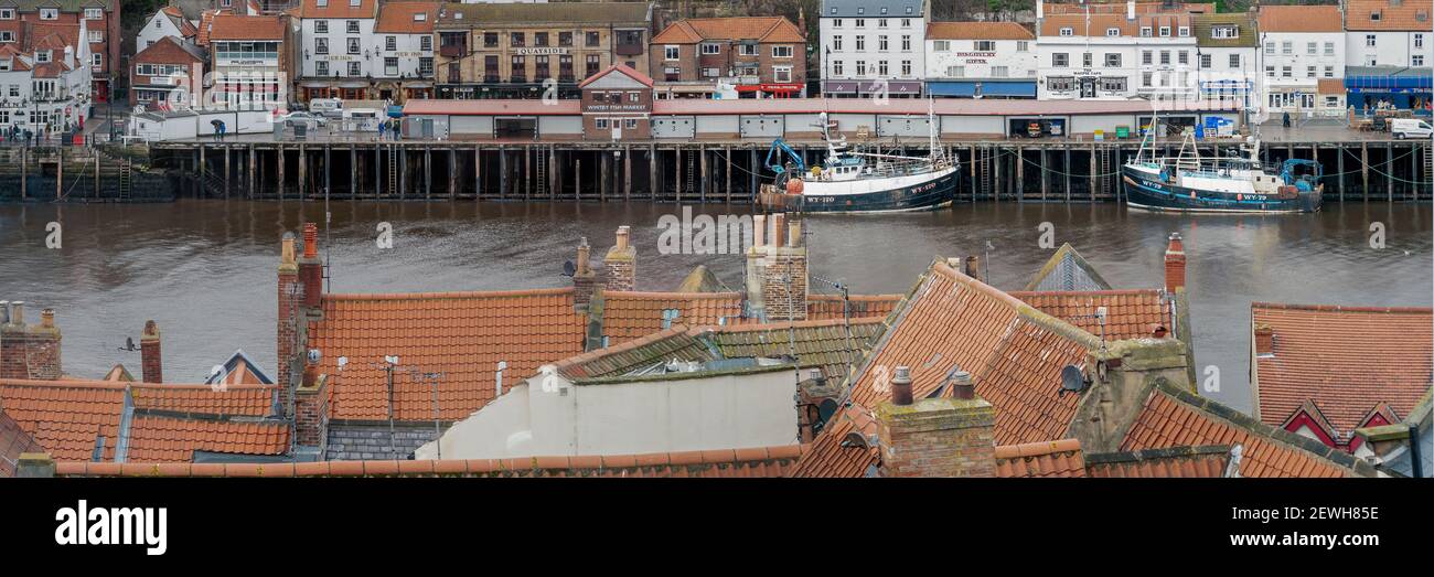 WHITBY, NORTH YORKSHIRE, UK - 15. MÄRZ 2010: Panoramablick auf Trawler im Hafen über rote Pantile Dächer Stockfoto