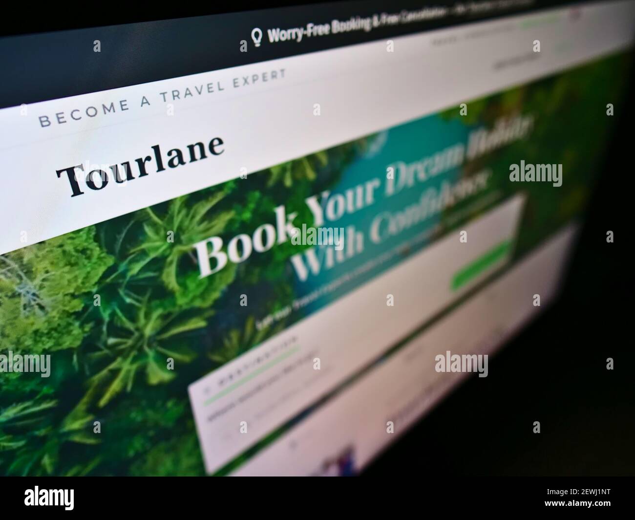 Hochwinkelansicht der Firmenwebsite mit Business-Logo des deutschen Online-Reisebüros Tourlane GmbH auf dem Monitor. Fokus oben links auf dem Bildschirm. Stockfoto