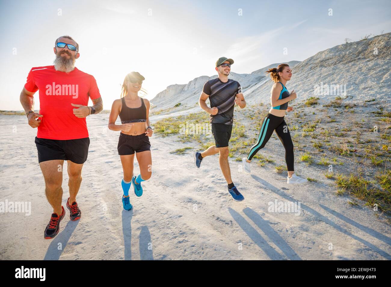 Vier Freunde laufen gemeinsam auf Trailrunning Stockfoto