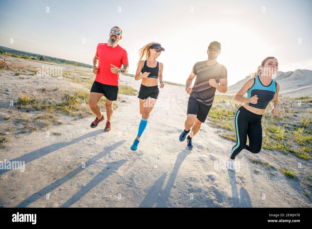 Vier Freunde laufen gemeinsam auf Trailrunning Stockfoto