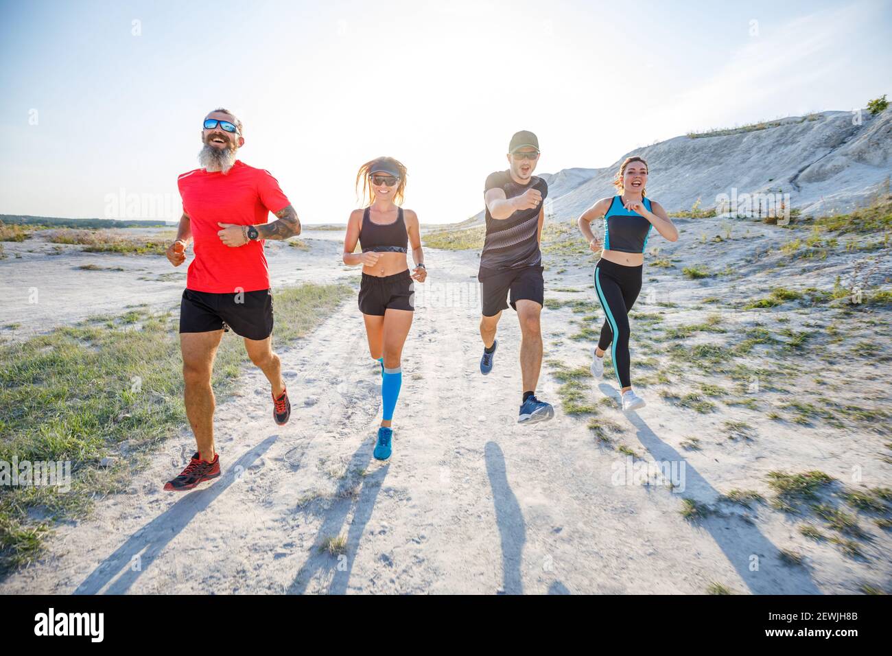 Vier Freunde laufen gemeinsam auf Trailrunning Stockfoto