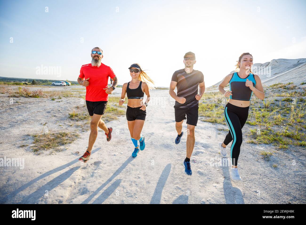 Vier Freunde laufen gemeinsam auf Trailrunning Stockfoto